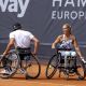 Ein Tennisspieler und eine Tennisspielerin im Rollstuhl die sich anschauen